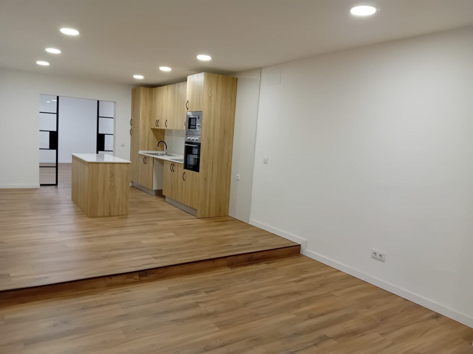 Mobiliario de cocina a medida con columnas de almacenamiento integradas por Reformas Ruigar